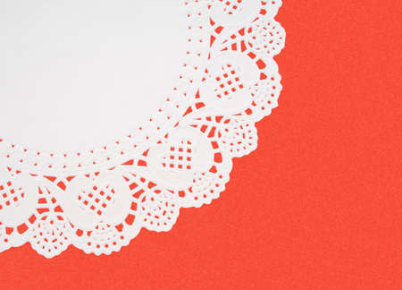 White embossed doily on red textured backgroundの写真素材