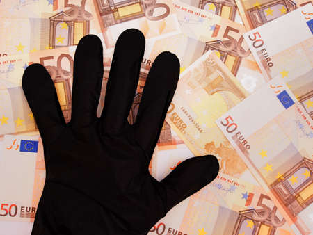 Hand in black glove taking stealing Euros money currency.の写真素材