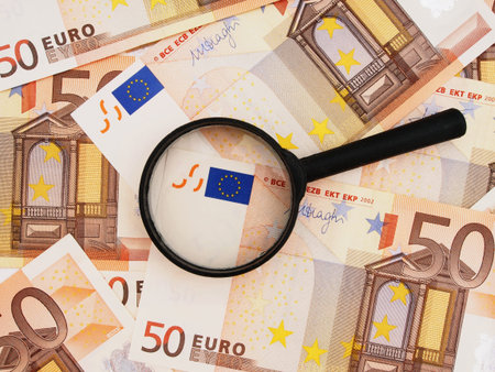 Financial crisis Grexit Euro zone currency under magnifying glass.