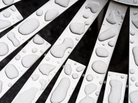 Raindrop shapes on aluminium bench detail. Abstract.