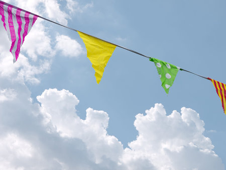 Festive real fabric bunting over sky.の写真素材