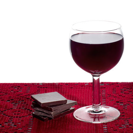Red wine and dark chocolate. On red lace. White background.の写真素材