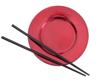 Plain chopsticks on red plate, isolated.の写真素材
