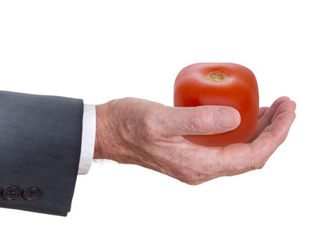 Businessman's hand with square tomato. White background.の写真素材