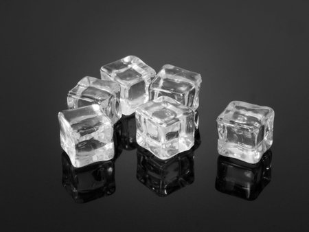 Plastic ice cubes reflected on textured surface