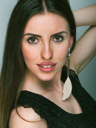 Brunette with large eyes and feather earring.