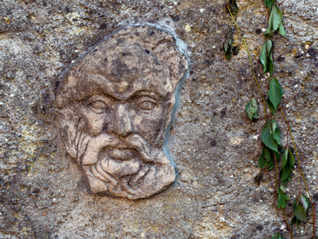 Stone carved face in wall. Architectural detail. Italy.の写真素材