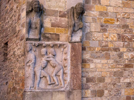Mmedieval stone carving outside church, Fornovo di Taro, Italy. Men seem to be fighting.の写真素材