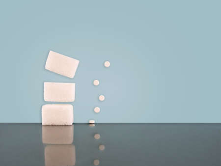 White sugar cubes and aspartame tablets. With reflections and copy space.の写真素材
