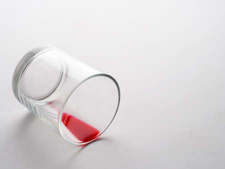 Glass with red liquid like blood. Pain or loss metaphor.の写真素材