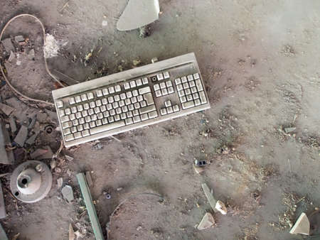 Old computer keyboard in dust. Forgotten and left behind when office closed.の写真素材