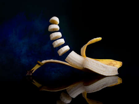 Fun fruit image. Bouncy banana on dark blue background.の写真素材