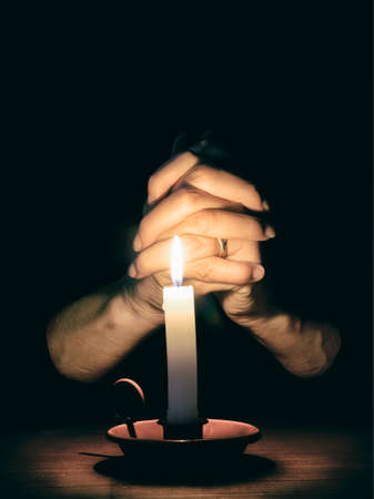 Religious image. Mature woman in prayer. Slightly desaturated for effect.の写真素材