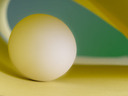 White marble ball in green and yellow, abstract background.