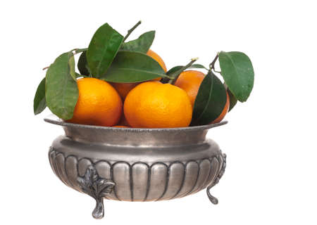 Small oranges, tangerines, with leaves in vintage pewter bowl, isolated on white.の写真素材