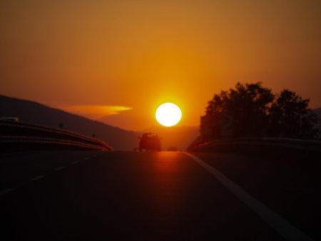 Motorway sunset, with holidaymaker cars returning from vacation, holiday. Homeward bound. Genuine...