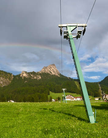 Summer view of Selva di Val Gardena, Italy looking up the ski slope, after rain with genuine rainbow. In Alto Adige, Dolomites.の写真素材