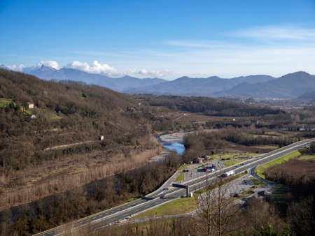 Lunigiana, north Tuscany, Italy. View from Lusuolo over motorway towards Apennine mountains. Unidentifiable vehicles etc. Sunny spring day, 2020.の写真素材