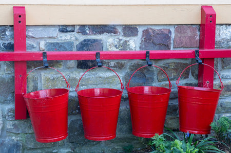 Four red buckets hanging on a wall. Backgound maybe.