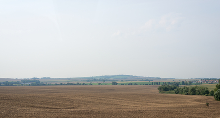 Landscape view with fields, village and green bushesの写真素材
