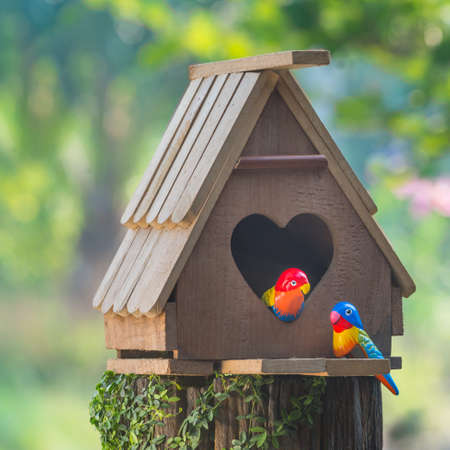 Birdhouse have a heart-shaped entrance and two love bird made from stuccoの写真素材