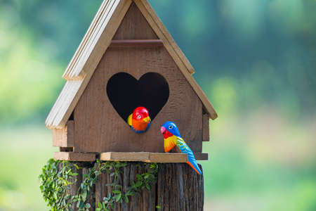 Birdhouse have a heart-shaped entrance and two love bird made from stuccoの写真素材