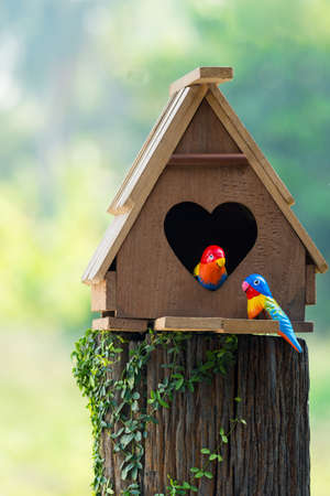 Birdhouse have a heart-shaped entrance and two love bird made from stuccoの写真素材