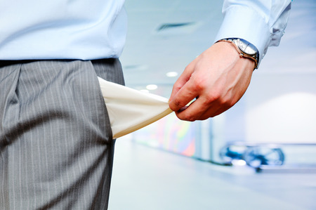 Man Pulling out Empty Pocket on office backgroundの写真素材