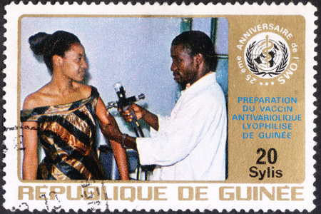 MOSCOW, RUSSIA - JANUARY, 2016: a post stamp printed in REPUBLIC OF GUINEA shows vaccination of a woman, the series "The 25th Anniversary of W.H.O.", circa 1973のeditorial素材