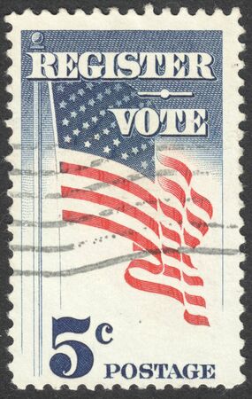 MOSCOW, RUSSIA - CIRCA APRIL, 2016: a post stamp printed in the USA shows the US flag on a pole waving with inscription "Register Vote", circa 1964のeditorial素材