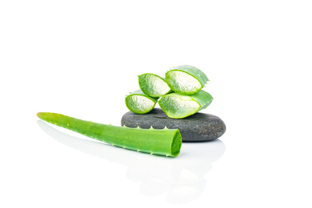 Sliced aloe leaves and spa stones on white backgroundの写真素材