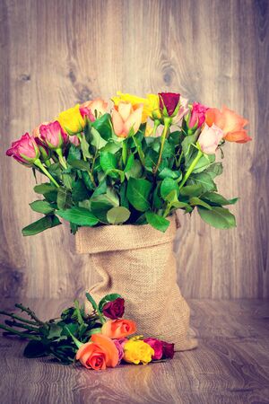 Roses in the sack on wooden backgroundの写真素材