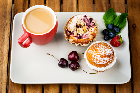 Cup of coffee and pastry on wooden backgroundの写真素材