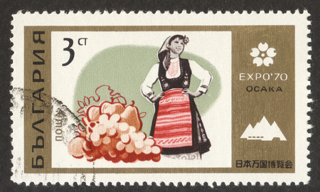 MOSCOW RUSSIA - CIRCA OCTOBER 2017: a post stamp printed in BULGARIA shows Female Bulgarian, Fruits, the series "EXPO â70, Osaka (II)", circa 1970のeditorial素材