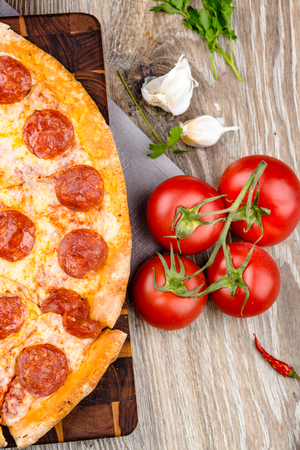 Photo of a hot pizza on wooden backgroundの写真素材