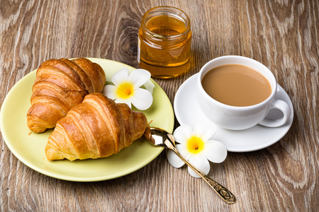 Cup of coffee and croissants on wooden backgroundの写真素材