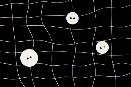 White threads and buttons net on black background