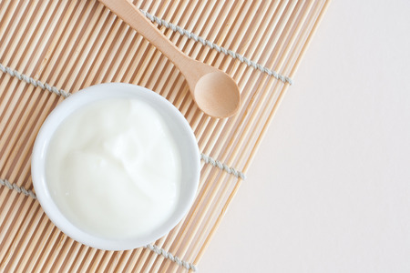 isolated wooden spoon and Natural Yogurt in a bowl - from about - studio shotの写真素材
