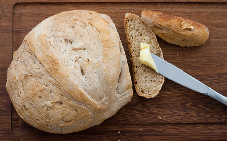 knife, home made bread and butter on wooden board - studio shotの写真素材