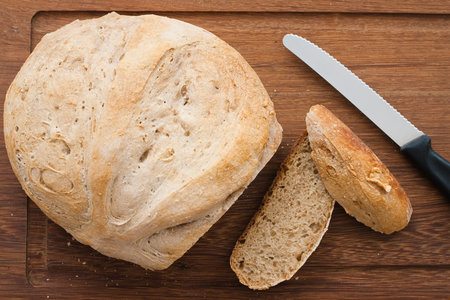 knife and home made bread on wooden board - studio shot