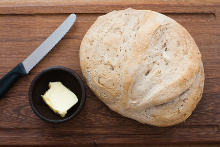 knife, home made bread and butter on wooden board - studio shotの写真素材