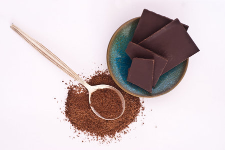 Cocoa and chocolate pouder tablets over white background from above