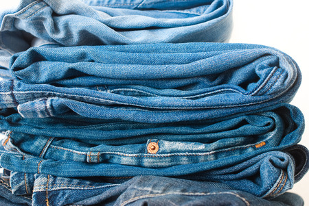 Jeans stacked on a white background - studio shotの写真素材