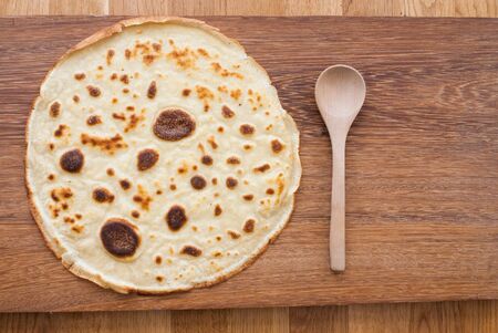 round pancake on wooden board - from above - studio shotの写真素材