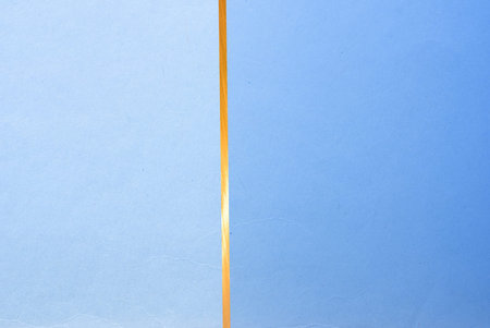 golden line on color paper background - abstract graphic design