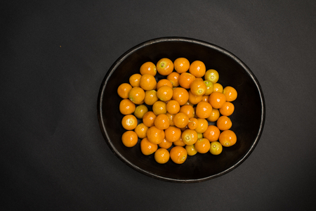 physalis fruits in a bowl - studio shot on black background from aboveの写真素材