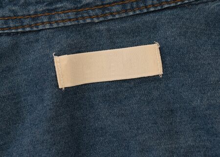 empty white label on blue denim textileの写真素材