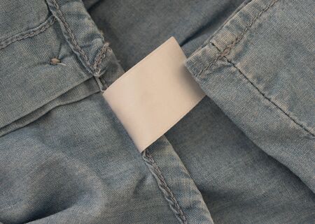 empty white label on blue denim textileの写真素材