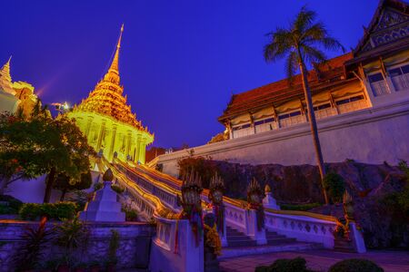 Buddhist church with naga along with ladder after sunset in Buddhist temple of Lobburi, Thailandの写真素材