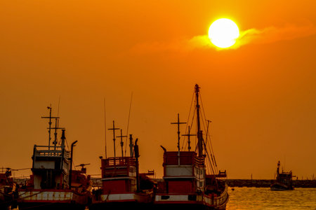 Fishing boats are parking at sea port during sunset.の写真素材